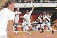 Shiner coach Brandon Siegel waves runner Amber Shimek around third 
